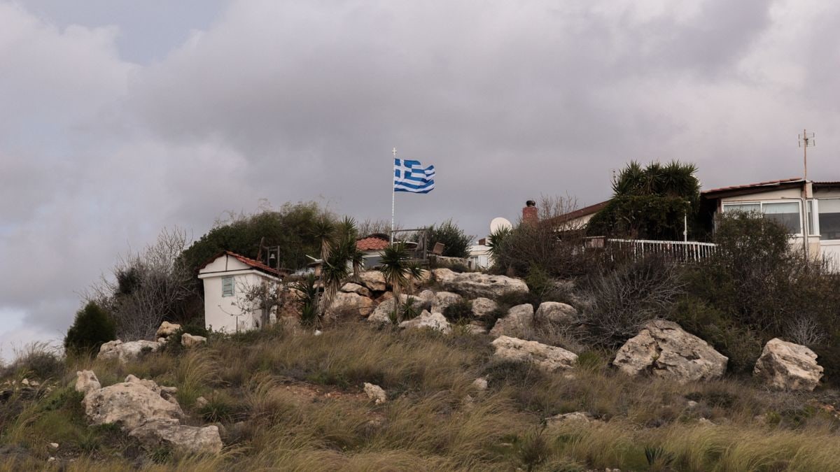 Charming rural landscape with a Greek flag on a rocky hill in Paphos, Cyprus.