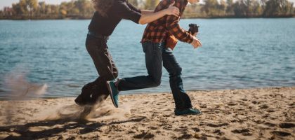 a man and woman dancing on a beach