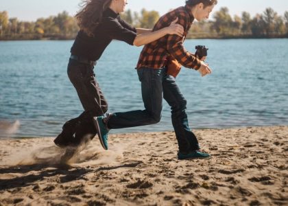 a man and woman dancing on a beach